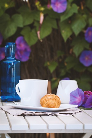 Delicious croissants with cup of coffee for breackfast on white tableの写真素材