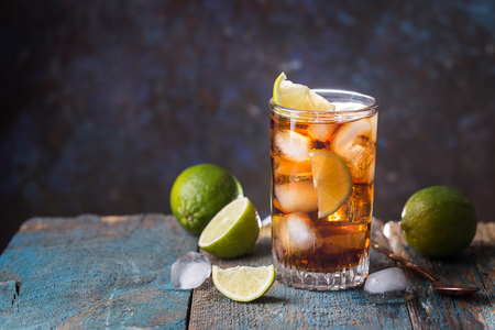 Fresh made Cuba Libre with brown rum, mint and lemon on woodenの写真素材