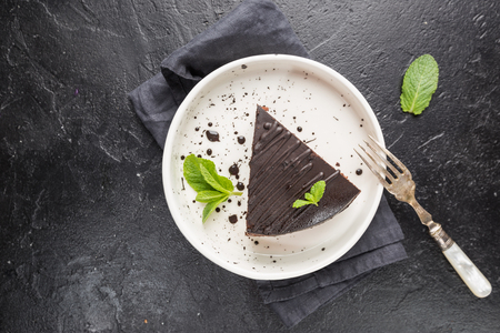 Delicious chocolate Prague cake on plate over darkの写真素材