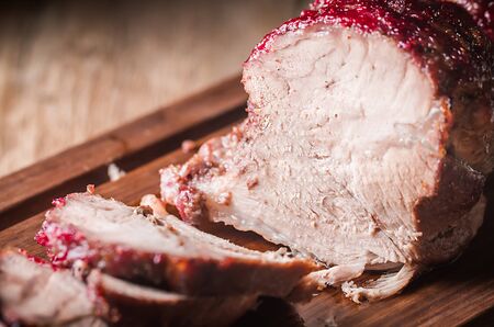 Baked pork meat with cranberry sauce and thyme over wooden background. Concepts of holiday food.の写真素材