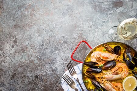 Traditional spanish seafood paella in a fry pan over gray background, top viewの写真素材