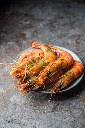 Giant fresh Tiger Prawns on plate over dark stone backgroundの写真素材
