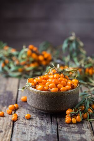 Sea-buckthorn berries in bowl on a wooden backgroundの写真素材