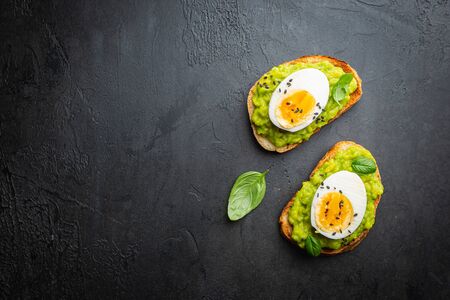 Healthy breakfast, toast with avocado and egg, top view, copy space. Vegetarian food concept