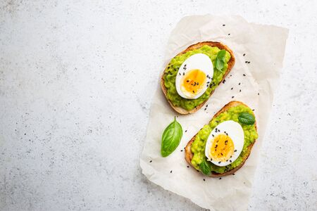 Healthy breakfast, toast with avocado and egg, top view, copy space. Vegetarian food concept