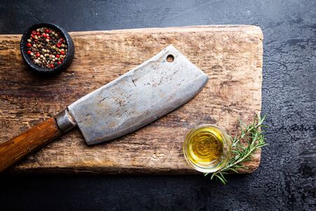 Cutting board, seasonings and oil set with meat cleaver on dark background, top view, copy spaceの写真素材
