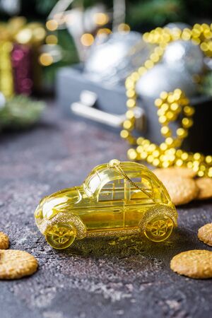 Yellow retro toy car delivering Christmas or New Year gifts on dark backgroundの写真素材