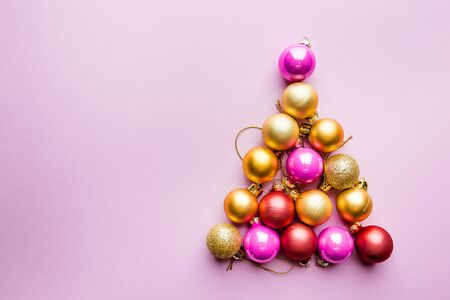 Christmas tree made of Christmas balls on pink background. Minimal styled New Year banner.の写真素材