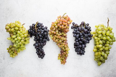 different colors, red, pink and white grapes over stone table. Top view with copy spaceの写真素材