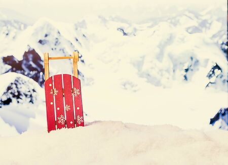 Sleigh in a snowdrift in front of snowy mountains. Winter Christmas background.