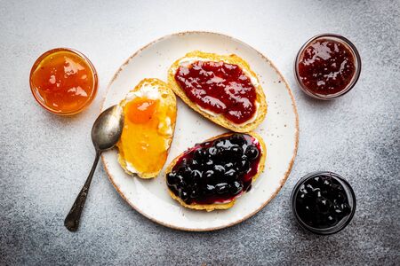 Sandwich with various sweet fruit jams and cottage cheese on light background, top view with copy spaceの写真素材