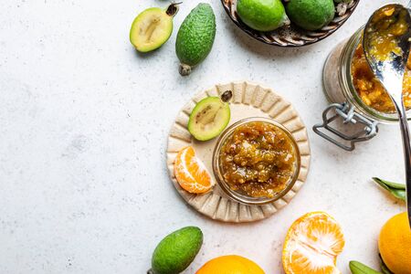 Tropical fruit preserves, homemade feijoa and tangerine jam with fresh fruits, top viewの写真素材