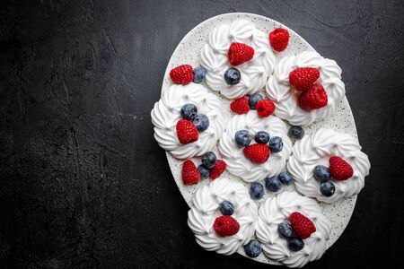 White meringues cakes with berries, raspberry and blueberry. Flat lay, top viewの写真素材