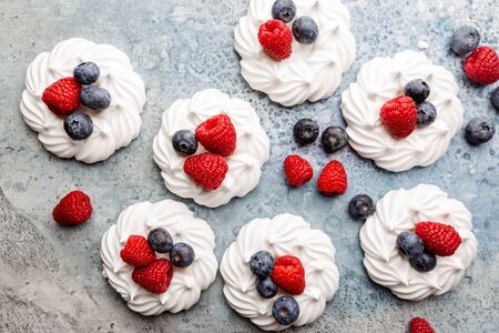 White meringues cakes with berries, raspberry and blueberry. Flat lay, top viewの写真素材