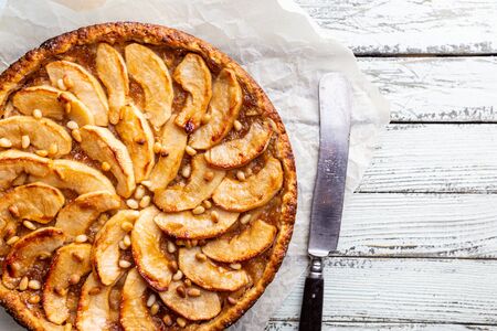 Homemade delicious fresh baked rustic apple pie on white wooden background, top viewの写真素材