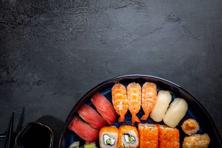 Set of sushi and maki with soy sauce over black background. Top view with copy spaceの写真素材