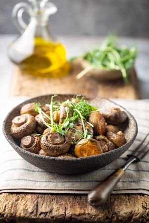 Baked champignons mushrooms with butter and roasted garlic in a bowl. Healthy food concept.の写真素材