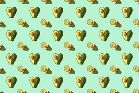 Trendy seamless sunlight Summer pattern made with avocado fruit on bright lcolorful background. Minimal summer concept.の写真素材