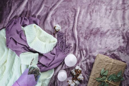 Women fashion cloth, accessories and office equipment. Flat lay female casual style look with warm white sweater on purple background. Top view.の写真素材