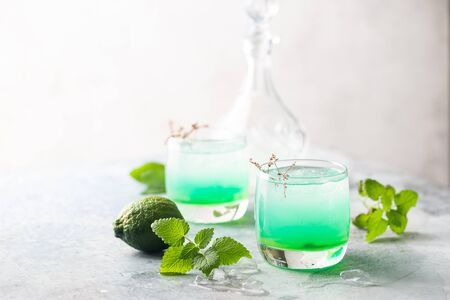 glass of cold drink with fresh mint leaves and ice cubesの写真素材