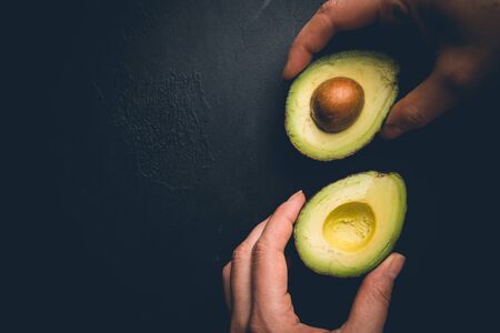 Fresh, raw avocado on a black background, top view