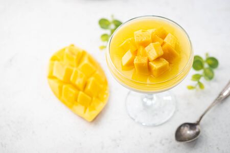Italian dessert panna cotta with mango in glass on white backgroundの写真素材