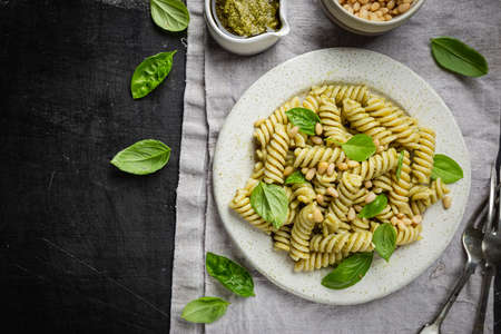 Italian Fussili pasta with basil pesto and fresh basil on black background. Top view.の写真素材