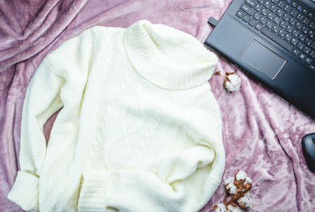 Women fashion cloth, accessories and office equipment. Flat lay female casual style look with warm white sweater on purple background. Top view.の写真素材