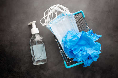 Medical background red. Medical surgical mask, sanitizer gel and lab gloves on Virus protection equipment, top view.の写真素材