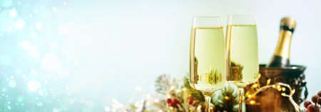 Champagne glasses and christmas decor on blue sparkling holiday backgroundの写真素材
