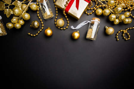Christmas holidays composition with gold decorations on black background with copy space for your...