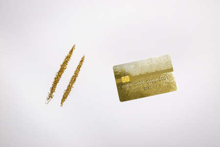 Golden dust or powder with gold credit card on white background, top view , copy space