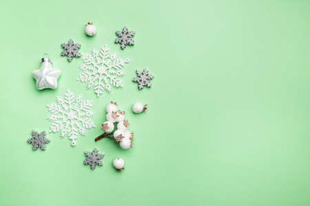 Christmas composition made of snowflakes on green background, top view. Winter concept. Flat lay.