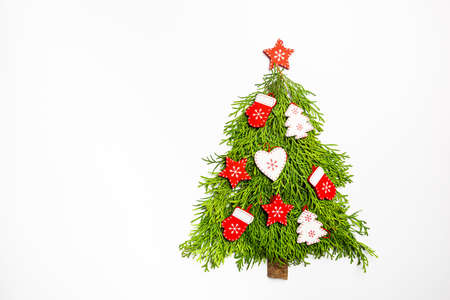 Christmas Tree made of thuja branches and wooden decorations on white background, top view. Holiday...