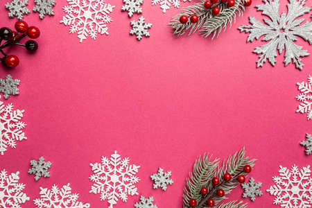 Christmas holidays composition with silver christmas decorations and snowflakes on pink background with copy space for your textの写真素材