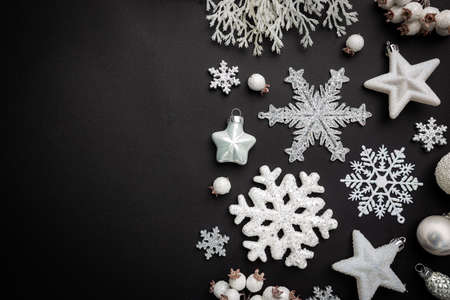 Christmas holidays composition with white christmas decorations and snowflakes on black background with copy space for your textの写真素材