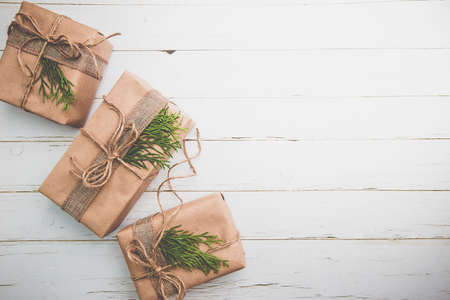 Christmas gift or present box wrapped in kraft paper with decoration on rustic wooden background, top viewの写真素材