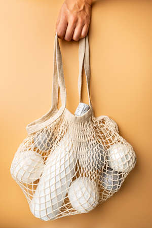 Christmas and New Year Composition. String bag with champagne and festive decor. Reusable shopping bag. Eco friendly mesh bags. Flat lay, top viewの写真素材