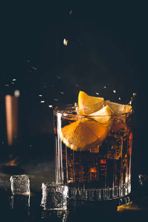 Fresh made Cuba Libre cocktail with brown rum, cola and lemon on wooden backgroundの写真素材