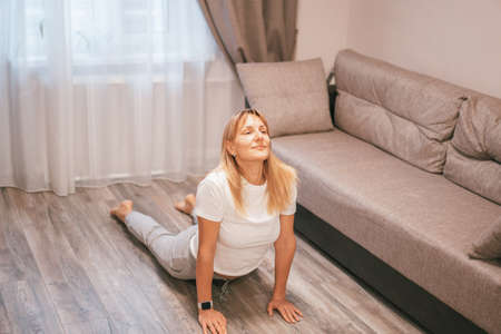 Woman doing yoga stretching yoga online at home. Healthy lifestyle concept. Self-isolation concept.の写真素材