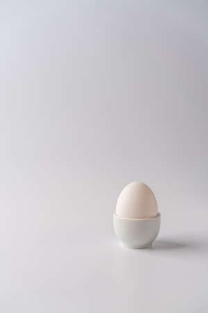 White egg on a white background with bright shadows