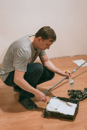 Home decorating mature man painting walls with paint rollerの写真素材