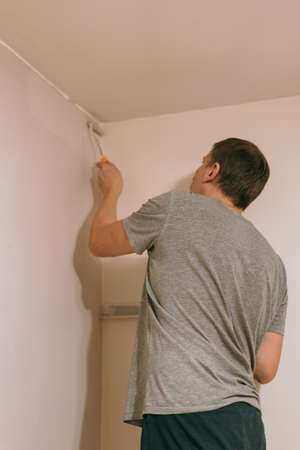 Home decorating mature man painting walls with paint rollerの写真素材