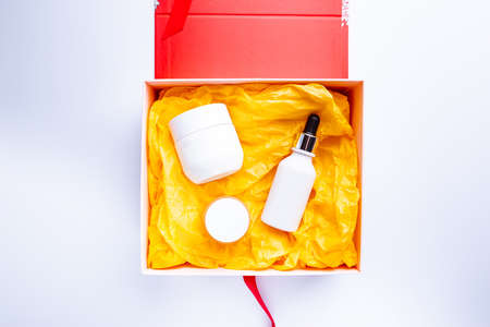 Flat lay composition with skin care products in gift box on white background