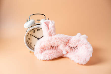 Sleeping eye mask, alarm clock isolated on pink pastel colourful trendy background. Do not disturb...