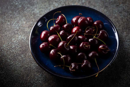 Fresh ripe cherry on blue plate close upの写真素材