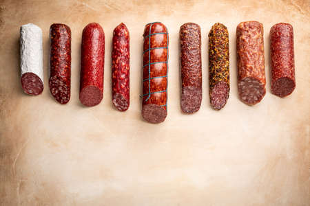 Set of different types of sausages, salami and smoked meat with basil and spices on light background. Top view.の写真素材