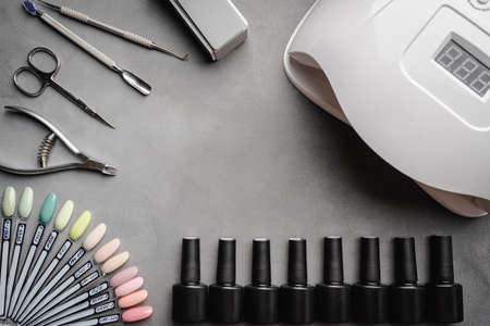 Set of manicure tools and accessories for nail polish and design on a gray background. Flat lay, top...