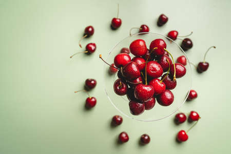 Top view of a ripe sweet cherry on green background