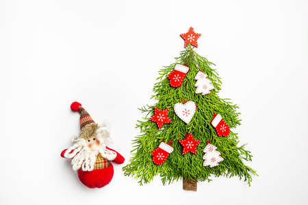 Christmas Tree made of thuja branches and wooden decorations on white background, top view. Holiday...